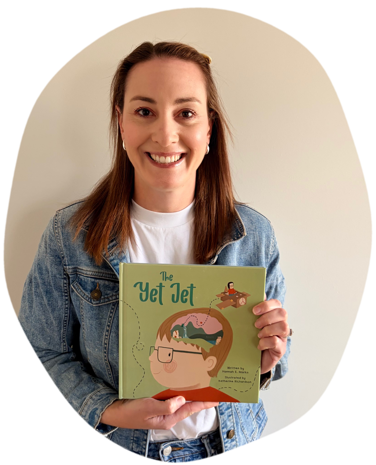 Author Hannah E. Marks smiling and holding a copy of The Yet Jet.